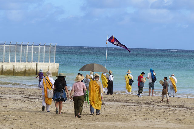 Some of the participants in the Okinawa Peace Walk at Henoko, with Kitsui carrying the umbrella. (Photo: Courtesy of Hakim)