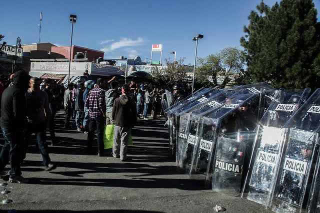Mexican police in riot gear form a line during a confrontation with protesters against increased gas prices in Mexico.