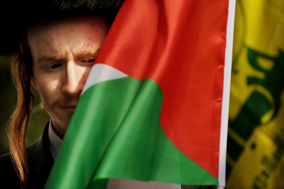 An Anti-Zionist Orthodox Jewish protester stands near a Palestinian flag during a demonstration in London on September 4, 2010.
