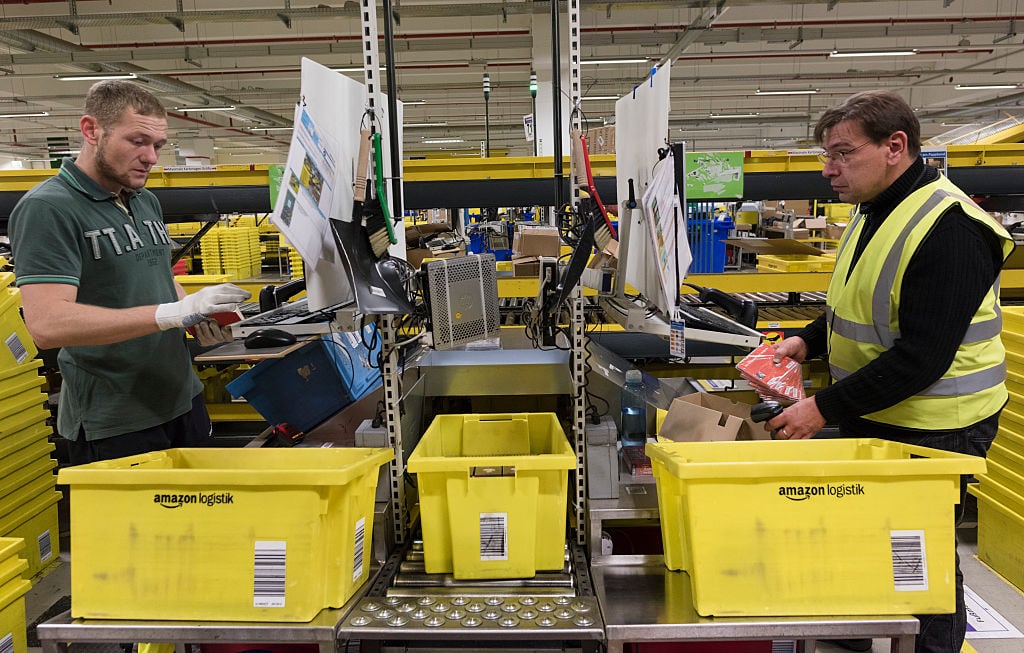 Workers process arriving merchandise in Amazon logistics center DUS2, a 110,000 sq. meters plant established in 2011, in Rheinberg, Germany, December 2, 2014.
