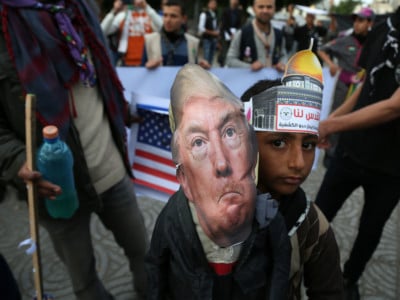 Palestinians carry an effigy bearing a poster of President Donald Trump during a protest against Trump's decision to recognize Jerusalem as Israel's capital, in Gaza City, December 13, 2017.