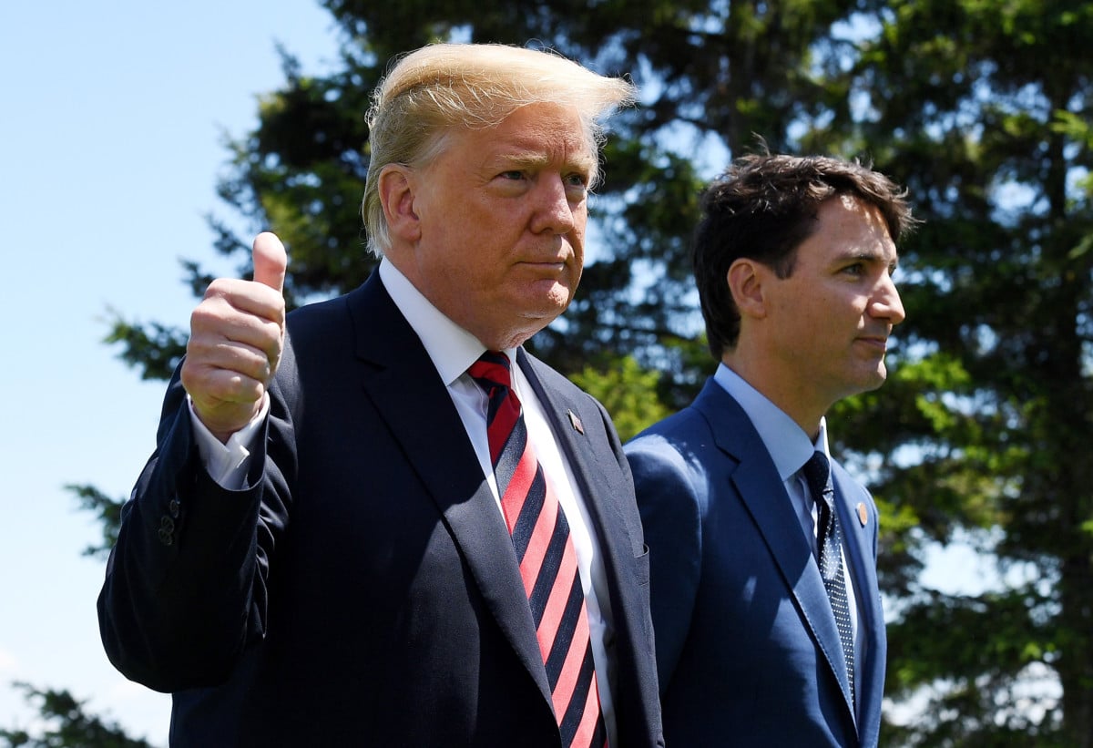 US President Donald Trump gives a thumbs up to the media as he is greeted by Prime Minister of Canada Justin Trudeau during the G7 official welcome at Le Manoir Richelieu on day one of the G7 meeting on June 8, 2018 in Quebec City, Canada.