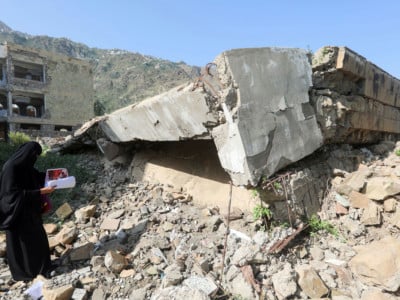 A Yemeni school administrator inspects damage to a school on the first day of the new academic year on September 16, 2018. The school suffered an airstrike last year during fighting between Saudi-backed government forces and pro-Iranian Huthi rebels in the country's third-largest city of Taez.