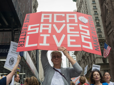 Participants hold signs while protesting the repeal and replacement of the Affordable Care Act during a rally on July 29, 2017.