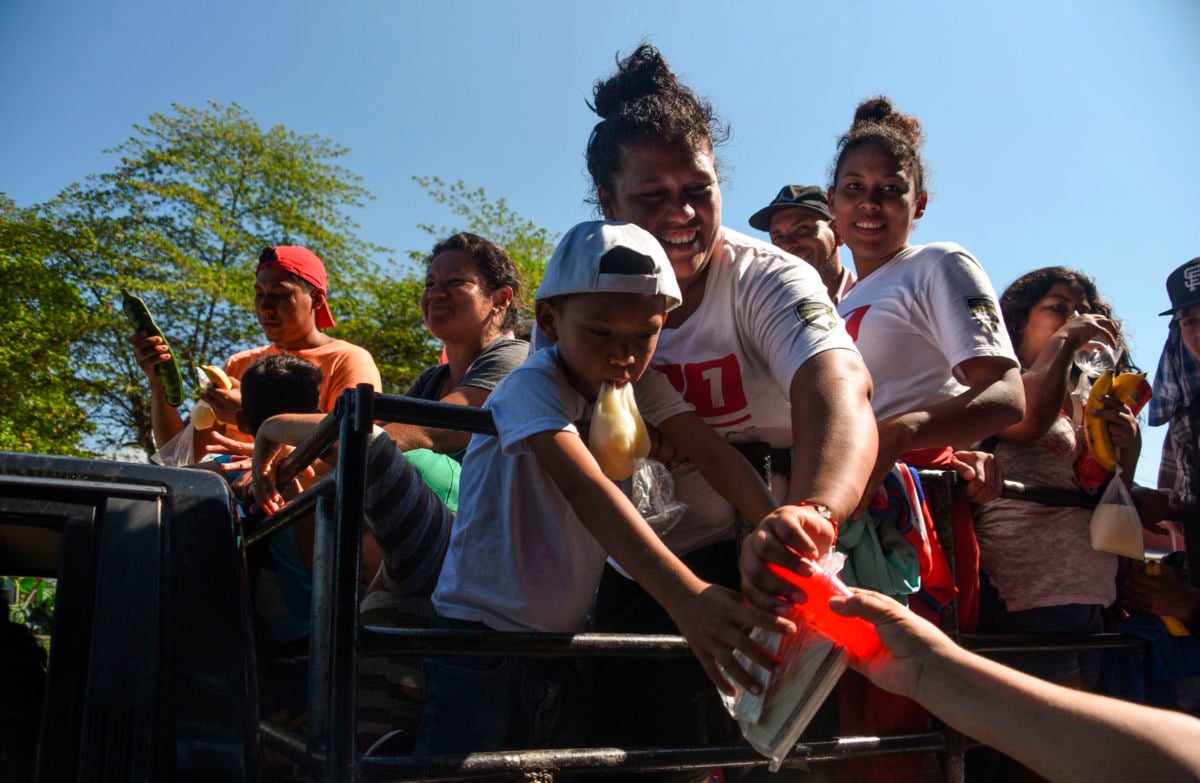 Honduran refugees aboard a truck in the migrant caravan headed to the US receive food donations in Acacoyagua, Chiapas State, Mexico, on October 24, 2018.