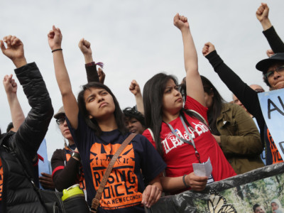 Activists raise fists during a rally organized in part by the National Domestic Workers Alliance in front of the White House to demonstrate against President Obama's immigration and deportation actions on April 28, 2014, in Washington, DC.