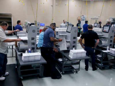 Elections staff load ballots into machines as recounting begins at the Broward County Supervisor of Elections Office on November 11, 2018 in Lauderhill, Florida.