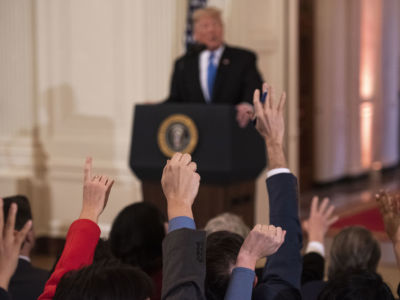 Reporters raise their hands to ask President Trump questions during a press conference in the East Room of the White House in Washington, DC, on November 7, 2018.