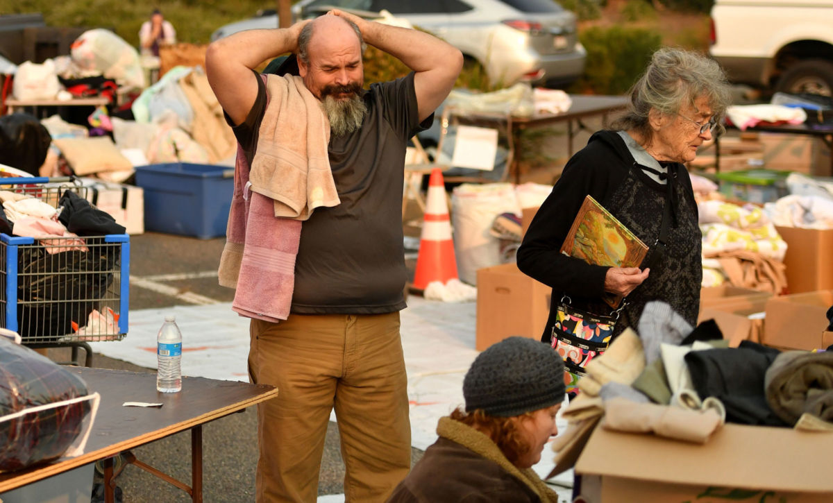 Evacuees search through donated clothing at an encampment in a Walmart parking lot in Chico, California, on November 17, 2018.