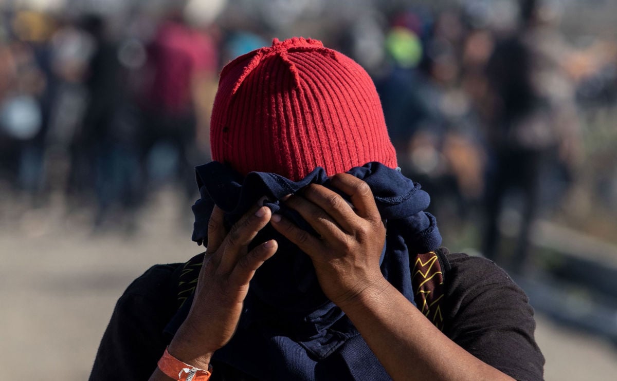 A Central American migrant covers his face near the El Chaparral border crossing in Tijuana, Baja California State, Mexico, after the US Border Patrol threw tear gas to disperse a crowd on November 25, 2018.