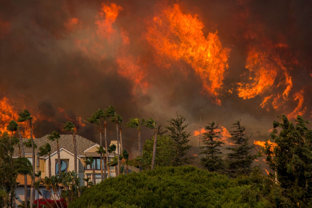 The Woolsey Fire approaches homes on November 9, 2018, in Malibu, California. About 75,000 homes have been evacuated in Los Angeles and Ventura counties due to two fires in the region.