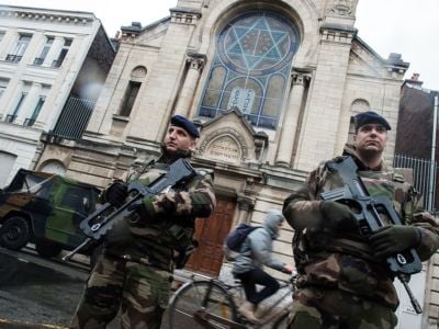 French soldiers stand guard in front of the entrance of a synagogue in Lille, northern France, on January 13, 2015. France announced on January 12 the unprecedented deployment of 10,000 soldiers to boost security, including at Jewish schools, a day after almost four million people marched in solidarity with the victims of the Charlie Hebdo massacre.