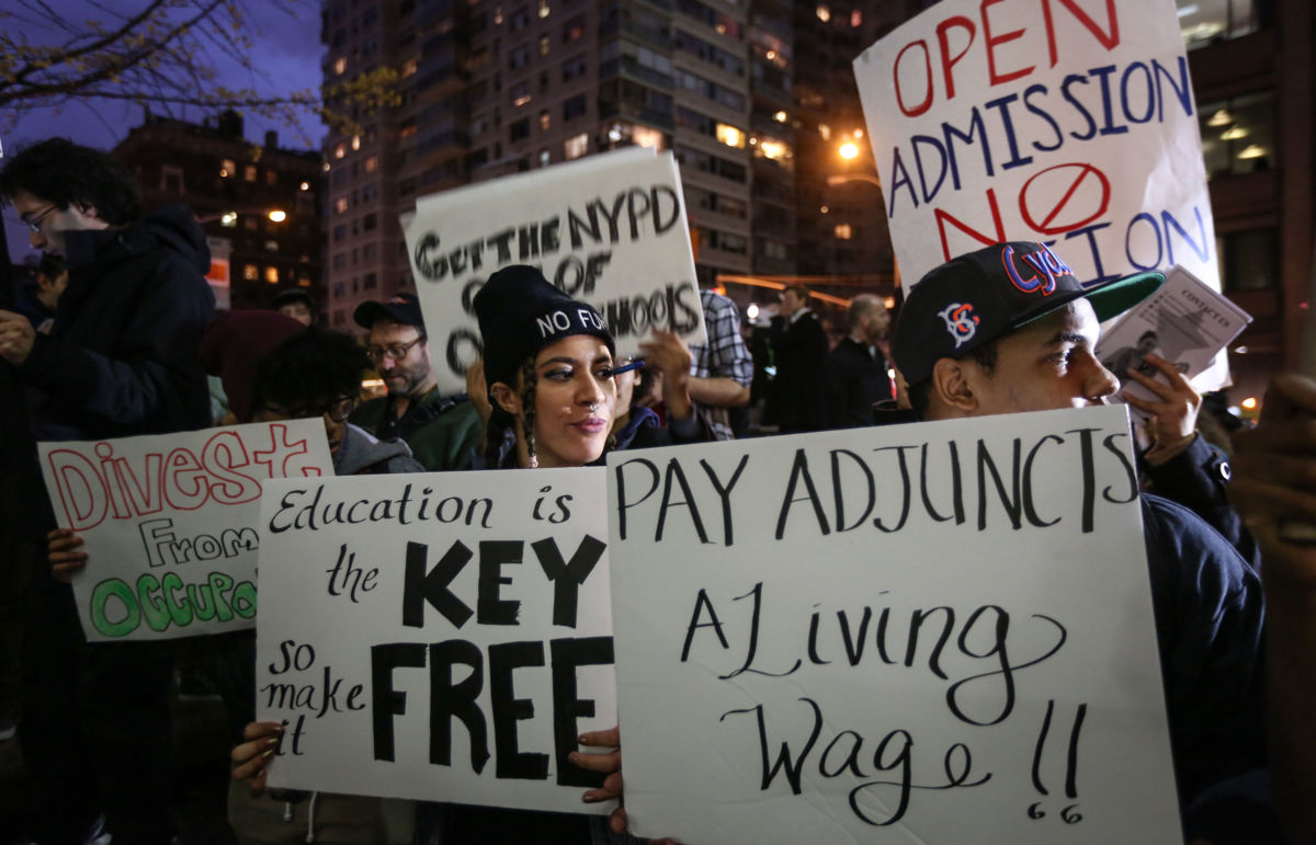 Students hold placards as they stage a demonstration at Hunter College, which is a part of New York City University, to protest ballooning student loan debt for higher education and rally for tuition-free public colleges in New York on November 13, 2015.