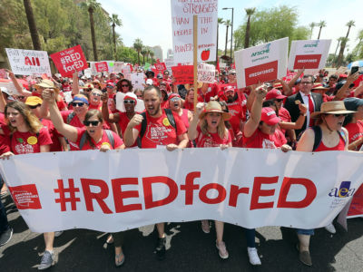 Thousands of Arizona teachers march through downtown Phoenix on their way to the State Capitol as part of a rally for the #REDforED movement on April 26, 2018, in Phoenix, Arizona.