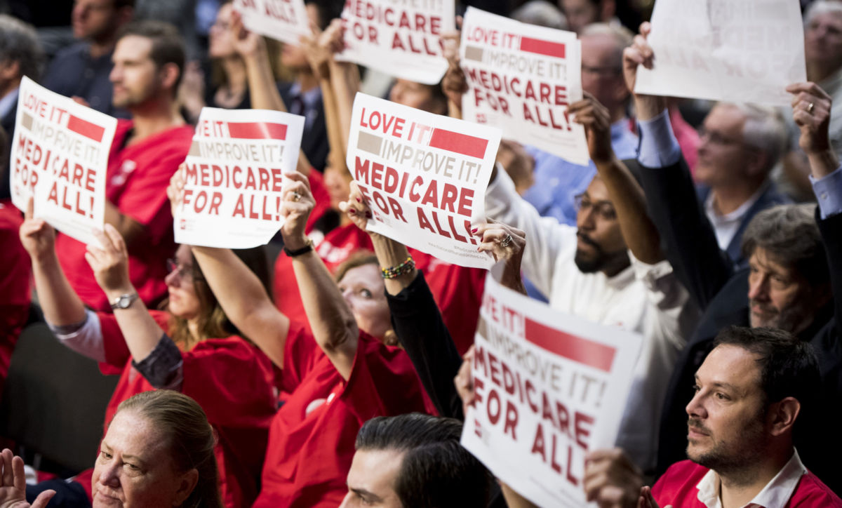 The audience waves signs as Sen. Bernie Sanders (I-Vt.) speaks during his event to introduce the Medicare for All Act of 2017 on September 13, 2017.