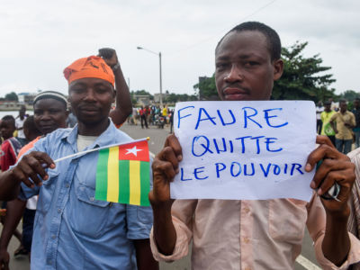 Protesters march and chant slogans during an anti-government protest led by a coalition of opposition parties in Lome, on September 7, 2017. Huge crowds turned out in Togo's capital for the second day running to demand political reform, in the largest opposition protests against President Faure Gnassingbe's regime. The placard reads 'Faure, resign'.