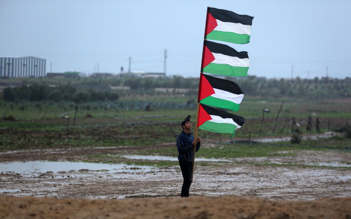 Palestinian protesters walk during a rainy day during a demonstration near the border with Israel east of Gaza city on December 28, 2018.