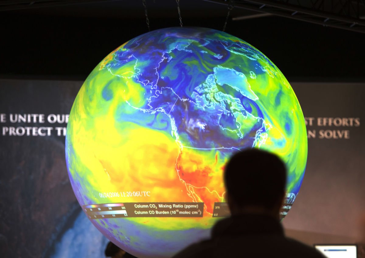 People watch the Earth globe at the COP21, the United Nations conference on climate change, in Le Bourget on December 10, 2015.