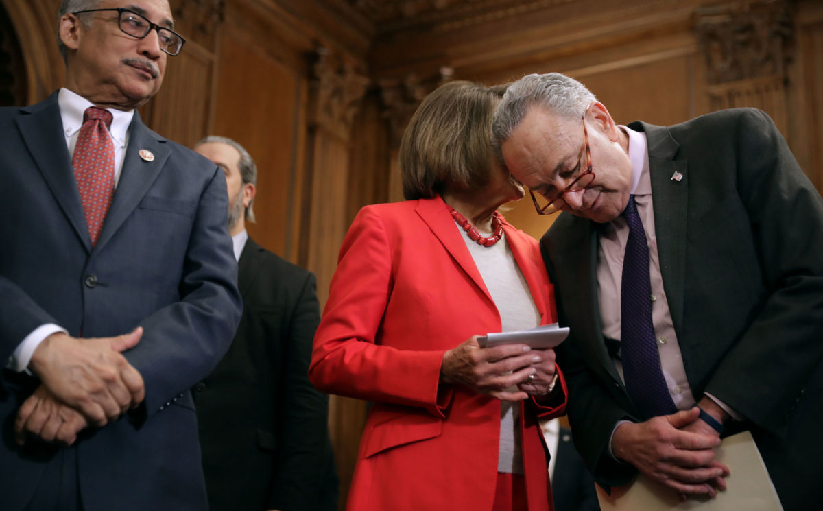Senate Minority Leader Charles Schumer and Speaker of the House Nancy Pelosi talk during an event to introduce the Raise The Wage Act with House Education and Labor Chairman Bobby Scott in the Rayburn Room at the US Capitol, January 16, 2019, in Washington, DC.