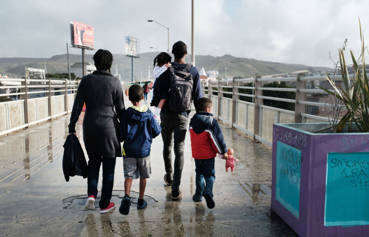 A migrant family walks across a bridge on January 18, 2019, in Tijuana, Mexico.
