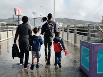 A migrant family walks across a bridge on January 18, 2019, in Tijuana, Mexico.