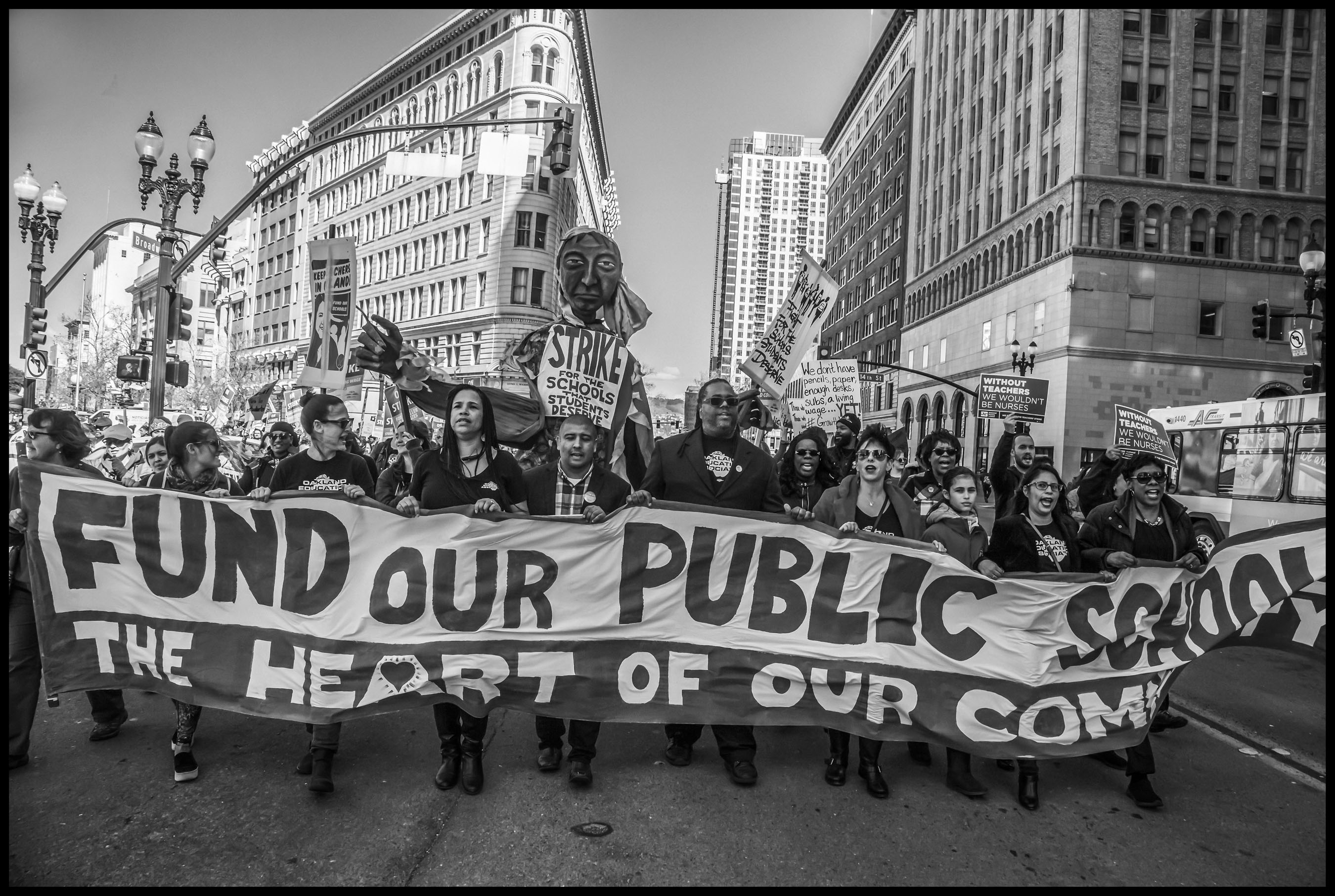 The strikers march behind their banner down Broadway, in downtown Oakland.