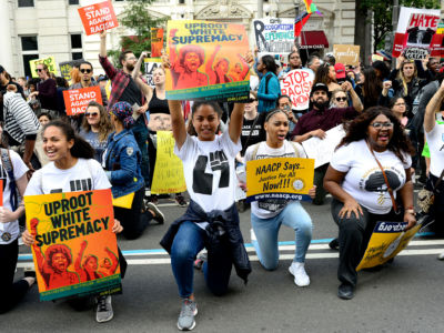 Protesters take a knee during the March for Racial Justice in Washington, DC, September 30, 2017.