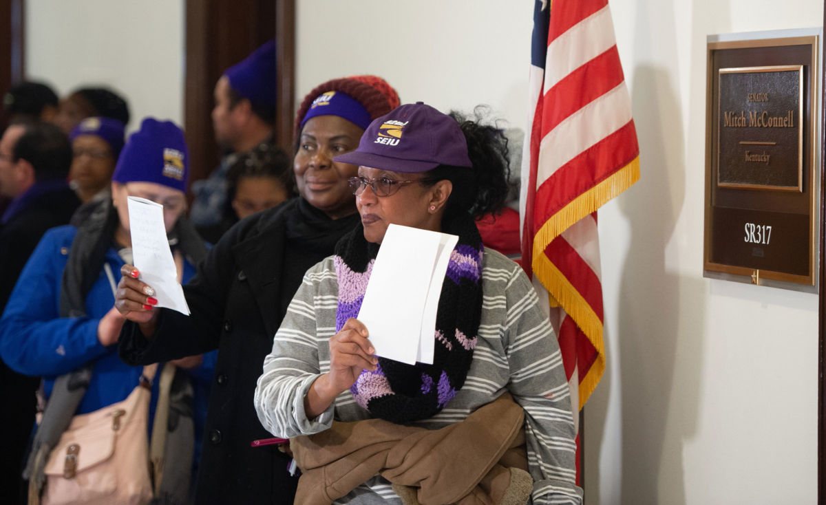 Furloughed contract workers, including security officers and custodians who have not been paid during the partial government shutdown, hold unpaid bills to present to the office of Senate Majority Leader Mitch McConnell on Capitol Hill in Washington, D.C., January 16, 2019.