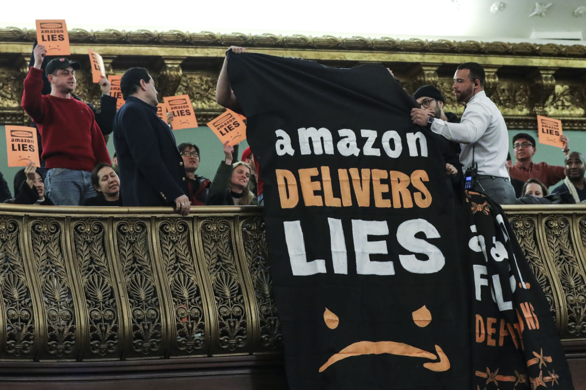Protesters unfurl anti-Amazon banners from the balcony of a hearing room during a New York City Council Finance Committee hearing titled "Amazon HQ2 Stage 2: Does the Amazon Deal Deliver for New York City Residents?" at New York City Hall, January 30, 2019.