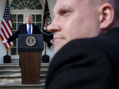 A White House Communications Agency staff member stands by as Donald Trump answers reporters' questions about border security in the Rose Garden at the White House February 15, 2019, in Washington, D.C. Trump said he would declare a national emergency to free up federal funding to build a wall along the southern border.
