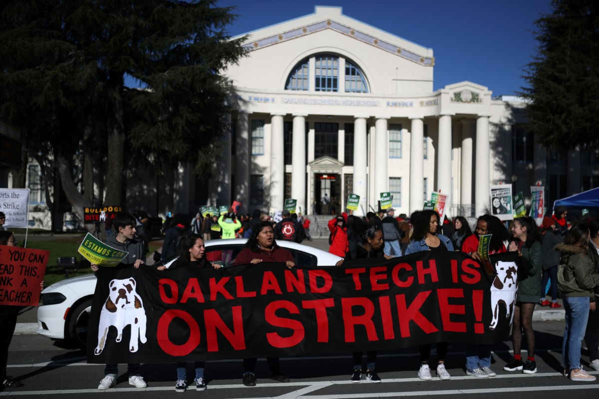 Oakland Unified School District students and teachers carry signs as they picket outside of Oakland Technical High School on February 21, 2019, in Oakland, California.