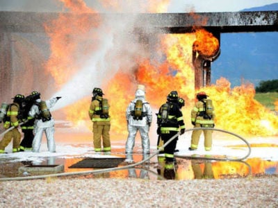Firefighters at Peterson Air Force Base conduct live training with AFFF. Notice the grassy area just beyond the foam. July 21, 2014.