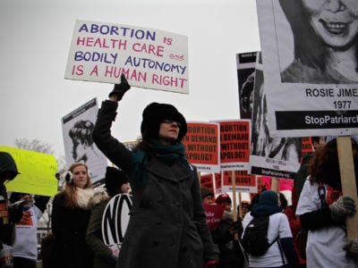 Pro-choice protesters march with signs.