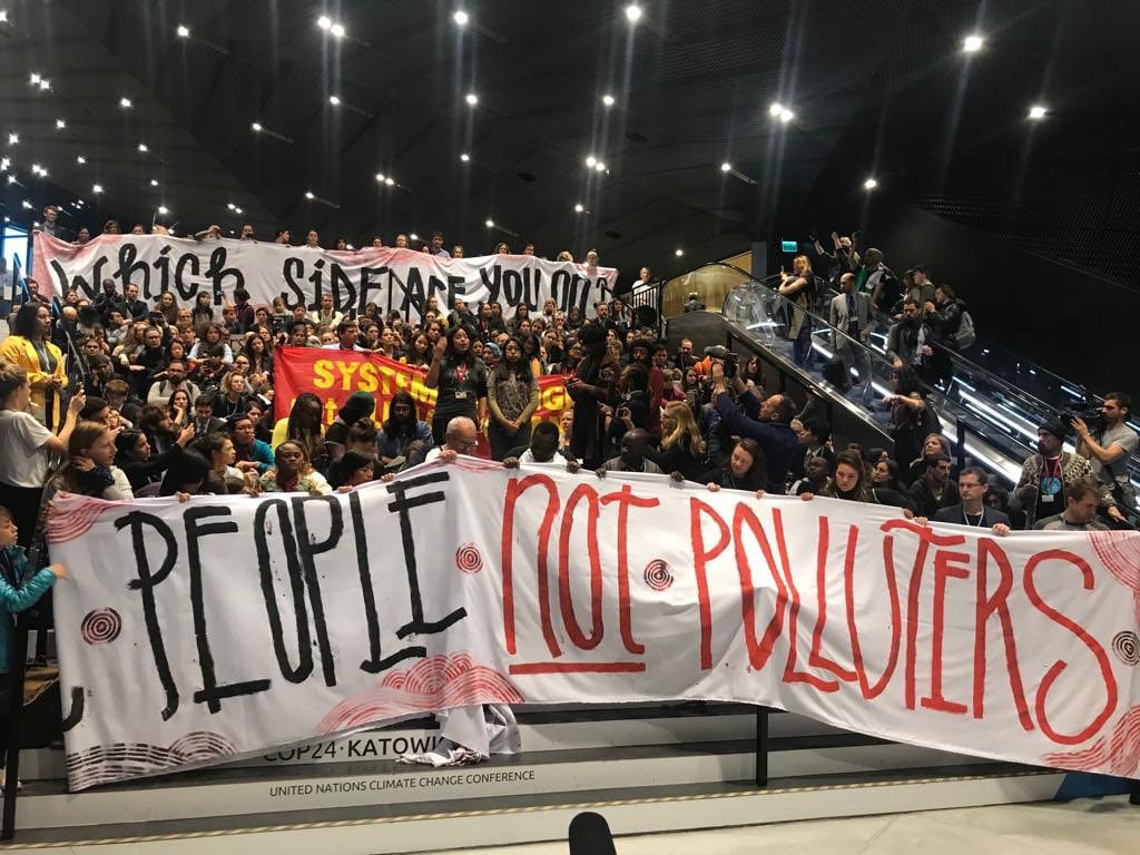 COP24 sit-in protesters hold banners calling for conflict of interest provisions. 