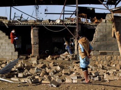 Man stands amid the rubble from airstrike in Yemen.