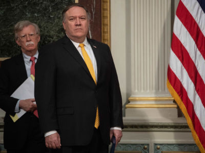 John Bolton and Mike Pompeo stand by a US flag at the White House.