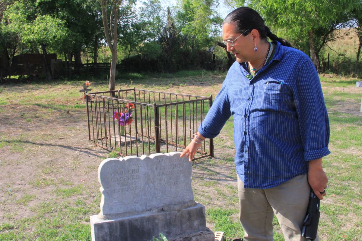 Christopher Basaldú points out the graves of Pauleno Caceres and Federico Jackson at the Eli Jackson Cemetery, on March 1, 2019, in San Juan, Texas, noting that the two were born and died on the same day.
