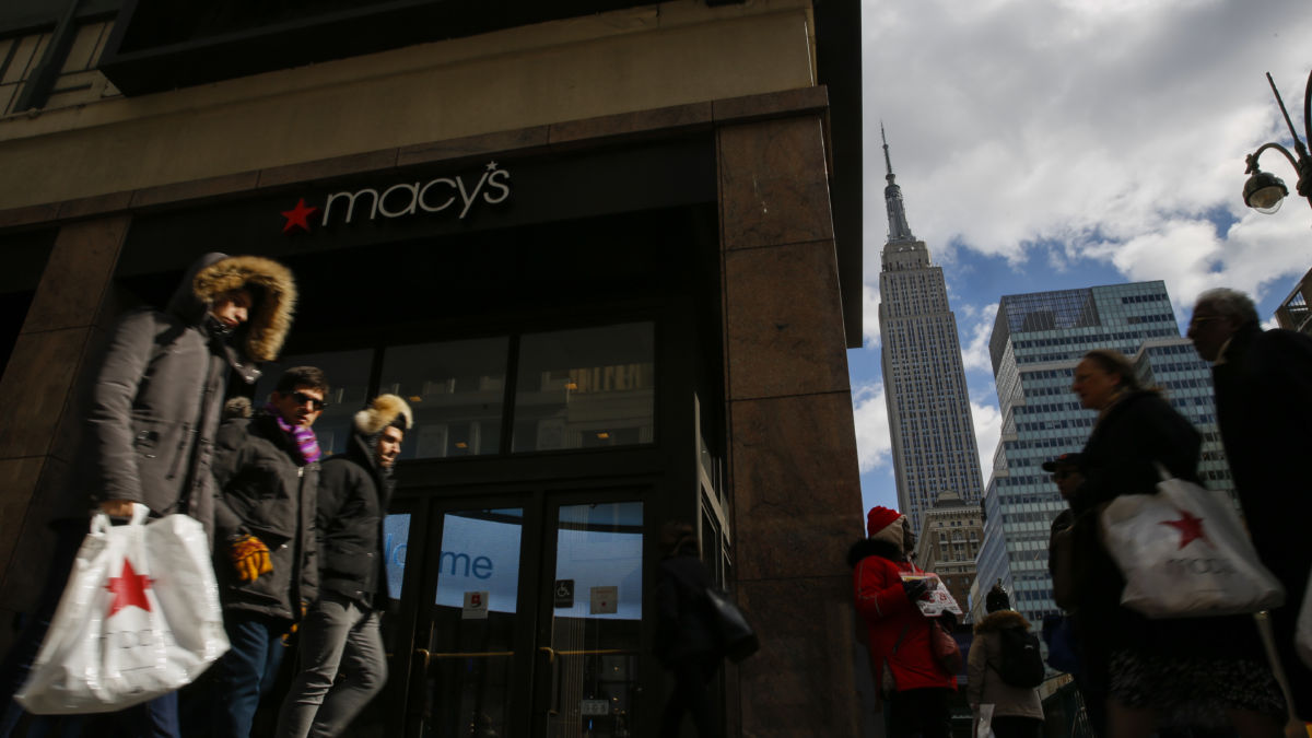 People walk in front of the Macy's headquarter as the Empire State Building is seen at the background on February 25, 2019, in New York City.