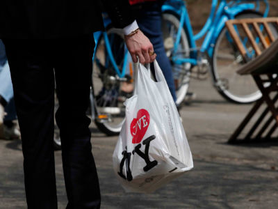 A man holds a plastic shopping bag as he visits Central Park on April 26, 2018, in New York City.