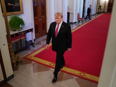 Donald Trump walks down a hallway