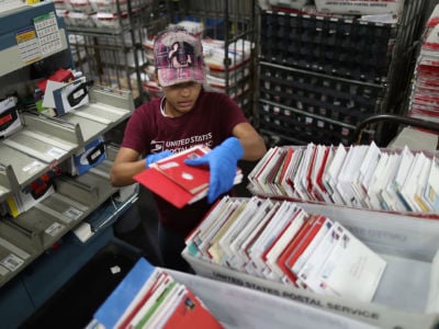 A U.S. Postal Service mail hander sorts mail