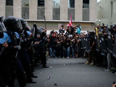 Police form a line in front of protesters during a May Day protest in San Juan, Puerto Rico