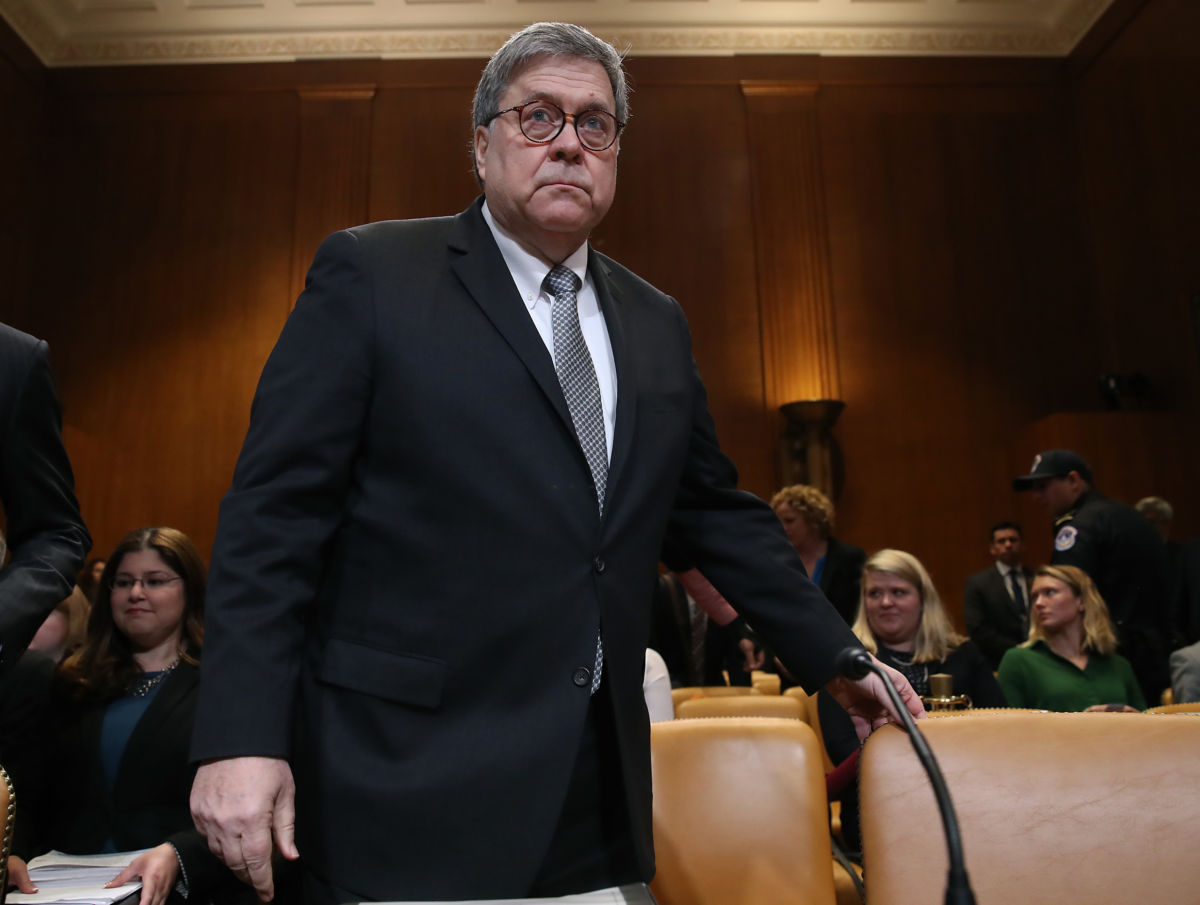 William Bar pulls out a chair from behind a desk