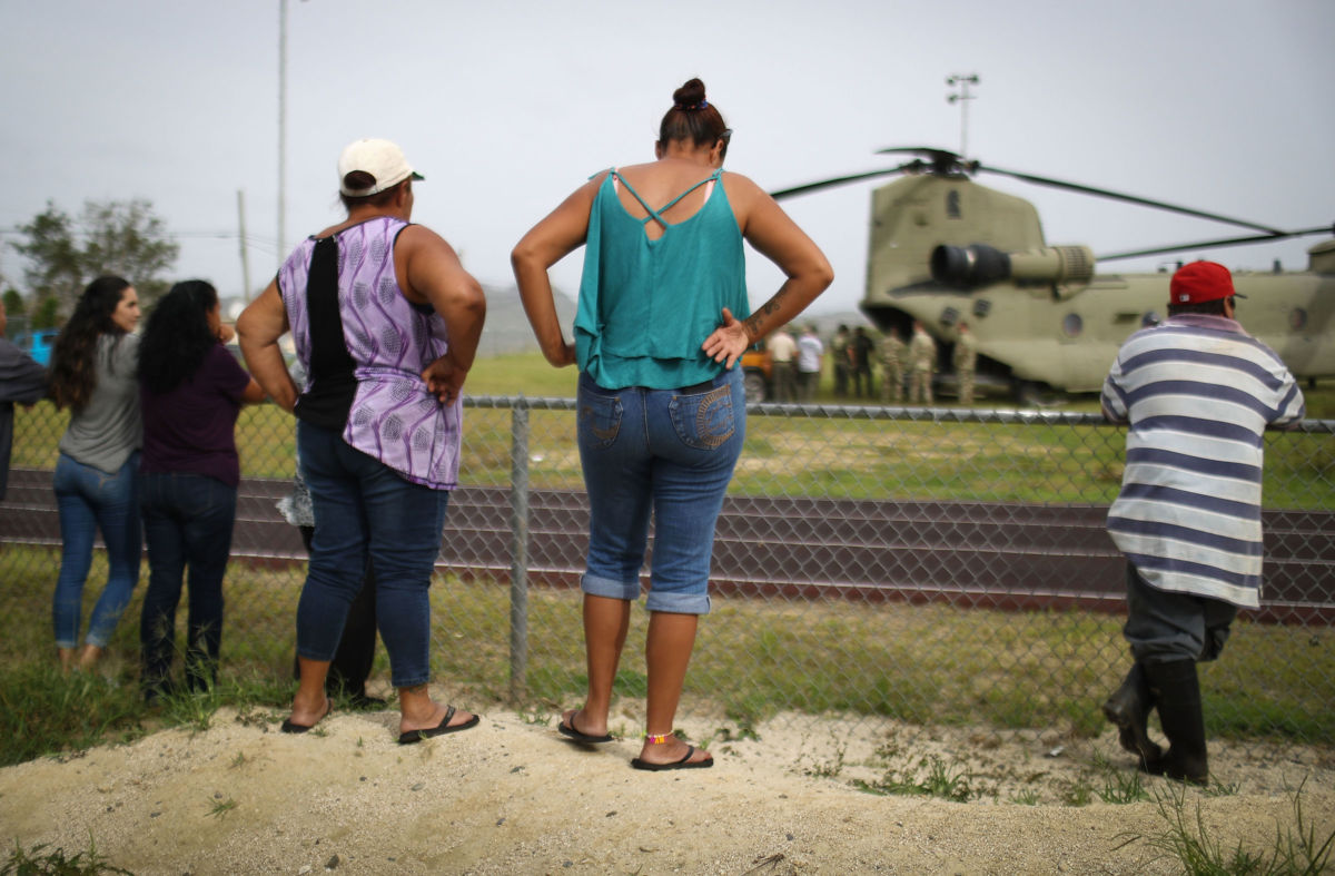 Local residents watch after a U.S. Army helicopter landed during food and water delivery efforts four weeks after Hurricane Maria struck on October 18, 2017, in Utuado, Puerto Rico.