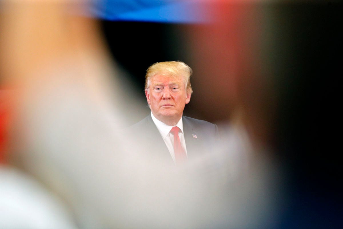 Donald Trump looks out from behind a blurry foreground