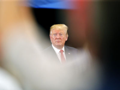 Donald Trump looks out from behind a blurry foreground
