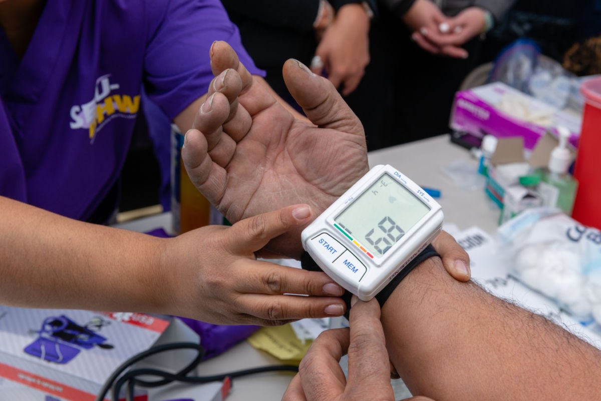 Someone gets their blood pressure checked with a wrist monitor