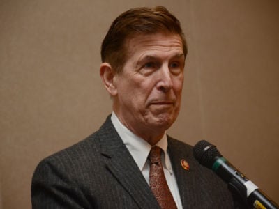 Don Beyer stands at a microphone