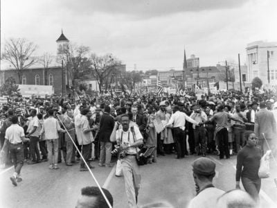 Marchers reach the culmination of the Selma to Montgomery March, Montgomery, Alabama, March 25, 1965. At left is the Dexter Avenue Baptist Church which served as headquarters for Martin Luther King Jr during the Montgomery Bus Boycott.
