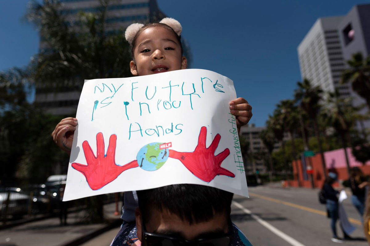 Alexa Ronnie Rojas holds a sign during a climate change demonstration in Los Angeles, California, on May 24, 2019. A forthcoming report warns our climate future, not to mention our current time, is turning out to be much worse than has been previously projected.